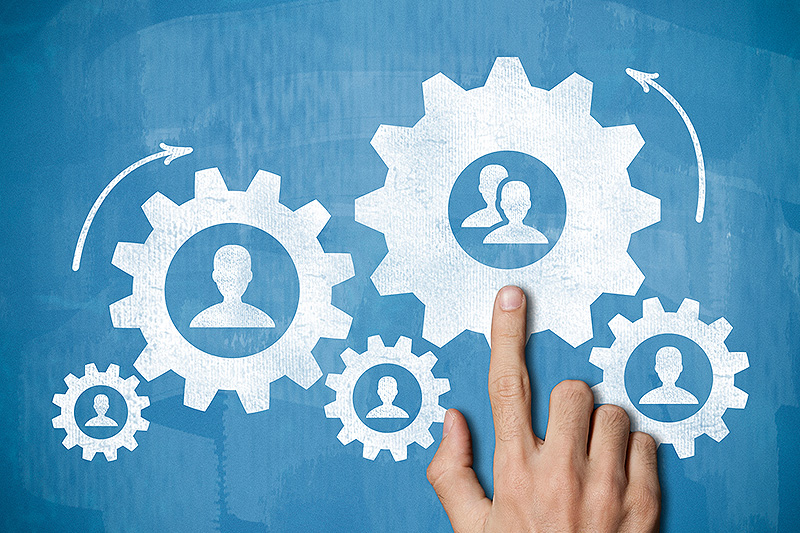 Hand pointing to person icons inside gear icon drawing